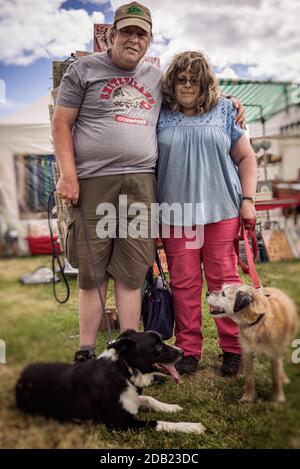 Un couple d'âge moyen à un spectacle de chiens dans le l'été avec leurs deux chiens Banque D'Images