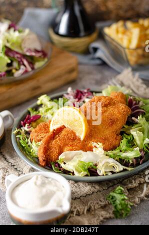 Pain croustillant schnitzel avec salade et sauce mayo Banque D'Images