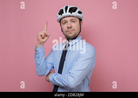 Homme cycliste porte un casque sur sa tête pointant vers le haut. Banque D'Images
