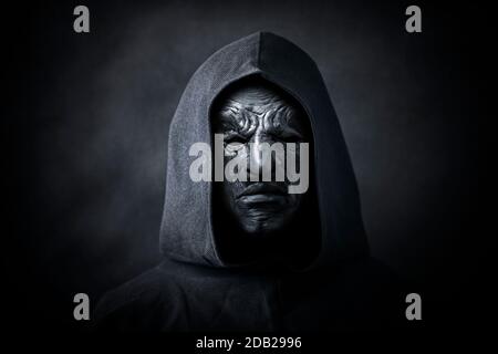 La figure effrayante dans hooded cloak avec masque Banque D'Images