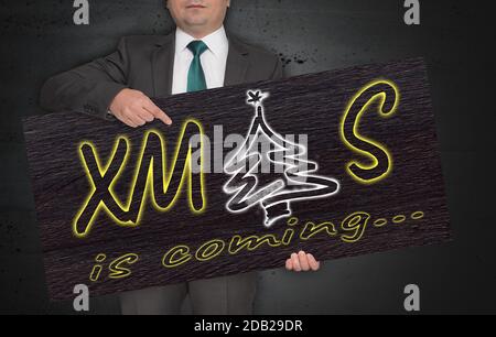 L'affiche DE NOËL est détenue par un homme d'affaires. Banque D'Images