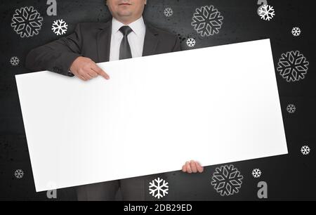 L'affiche du concept de flocons de neige est tenue par un homme d'affaires. Banque D'Images