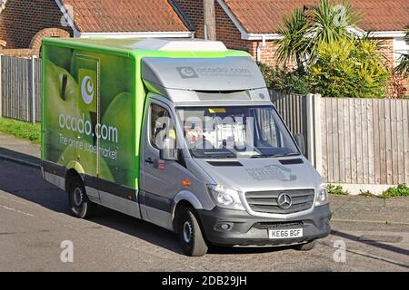 Vue latérale et avant d'en haut, vue sur le vert Fourgonnette de livraison d'épicerie en ligne Ocado et pilote de logo Conduite sur route résidentielle Angleterre Royaume-Uni Banque D'Images