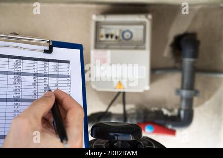 Presse-Papiers Worker Holding Inspection De La Pompe À Eau Et Des Tuyaux Banque D'Images