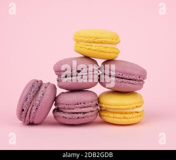 de nombreux gâteaux de macarons ronds multicolores sur un fond rose clair, se rapprochez Banque D'Images