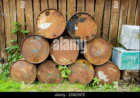 Vieux barils de pétrole rouillés empilés dans une cour à Norfolk, Angleterre, Royaume-Uni Banque D'Images