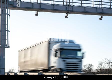 le camion traverse la route par la porte à péage, les frais de péage, les mouvements flous dans l'image. Banque D'Images