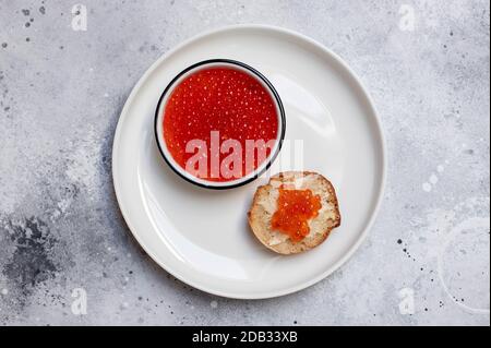 caviar rouge saumon dans un bol blanc sur fond clair. sandwich avec caviar rouge. cuisine de mer. vue de dessus Banque D'Images