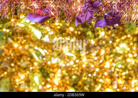 Plein de texture de fond flou d'or décoré de guirlandes de violet smiling faces chauves-souris en premier plan pour célébrer l'halloween. Banque D'Images