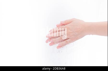 Femme se laver la main avec de l'eau isolée sur fond blanc. Bon concept d'hygiène personnelle. Première étape pour nettoyer les mains sales pour prévenir la grippe et le coronav Banque D'Images