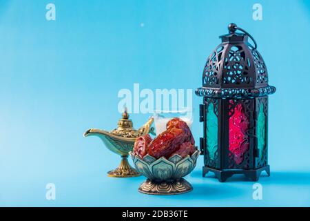 Ramadan Kareem concept alimentaire à jeun, dates de la plaque de bronze, lait, et lanterne Aladdin lampe décoration, eid festival religieux musulman arabe sur un ba bleu Banque D'Images