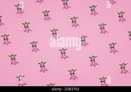 Lignes de contours de tapis gris des anges sur la surface rose. Décoration de Noël avec ombres. Arrière-plan sur le thème de Noël. Banque D'Images