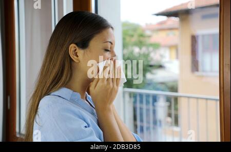 COVID-19 Pandémique masque de coronavirus Sick Femme éternuer, toussant nez labourant isolement à la maison quarantaine automatique pour la propagation du virus de la maladie SRAS-COV-2 Banque D'Images