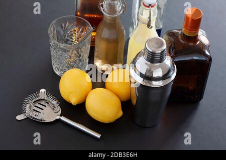 Accessoires de barre vus d'en haut. Buvez des outils et des ingrédients pour cocktail, dont un shaker, une passoire, un verre, une liqueur, des bouteilles de sirop faites maison et trois lème Banque D'Images