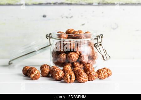 Noisettes avec glaçage au sucre dans le bol sur table blanche. Banque D'Images