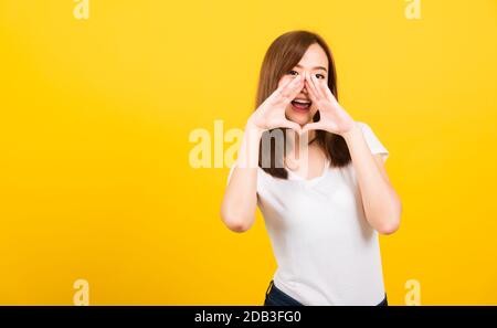 Portrait heureux asiatique belle jeune femme jeune ado se tenant grand shout avec les mains à la bouche suivante donnant excité positif regardant l'appareil photo isolé, Banque D'Images