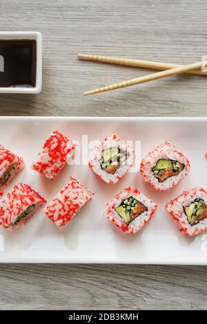 Vue sur le rouleau de sushi. Saumon, concombre, avocat et caviar pour les amateurs de sushis. Cuisine japonaise et chinoise. Banque D'Images