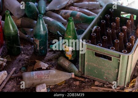 Vue sur un tas de bouteilles de bière et de soda abandonnées dans une grange. Banque D'Images