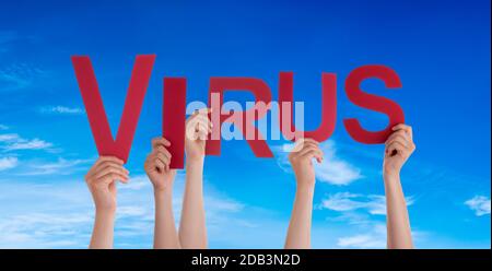 People Hands Holding Red English Word virus. Ciel bleu comme arrière-plan Banque D'Images