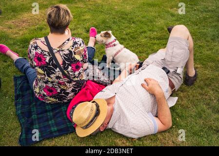 Un couple d'âge moyen avec un petit chien Jack Russell. Banque D'Images