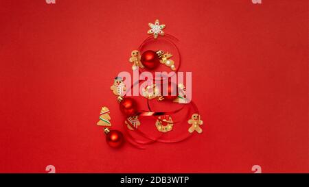 Arbre de Noël fait avec des biscuits de Noël et des boules de Noël arrière-plan rouge Banque D'Images