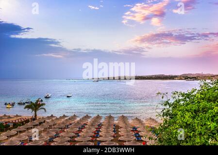 Parasols et chaises longues sur une plage en Egypte à lever du soleil Banque D'Images