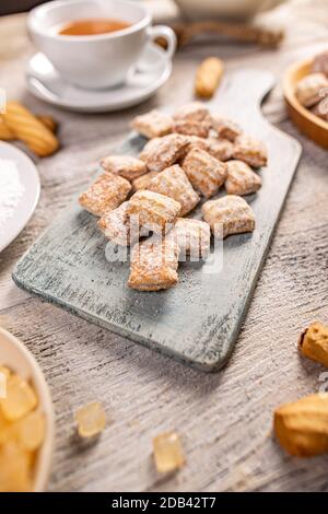 Biscuits saupoudrés de sucre en poudre servis sur une planche de bois Banque D'Images