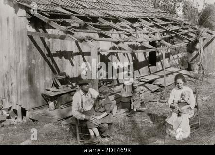 Frank Burditt et sa famille. Ils louent cette cabane délabrée et tentent de vivre au large de la terre maigre à proximité. . Banque D'Images
