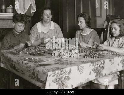 Cottage Industry montre le matériel de la famille de stringing dans le travail à la maison. Banque D'Images