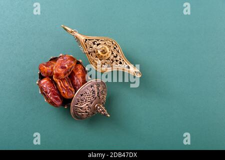 Ramadan, dates dans le bol doré et ont arabian Aladdin feu de style vintage sur fond vert noir Banque D'Images