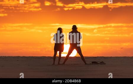 Couple regardant un coucher de soleil à la plage de Los Lances, Tarifa, Costa de la Luz, Cadix, Andalousie, Espagne Banque D'Images