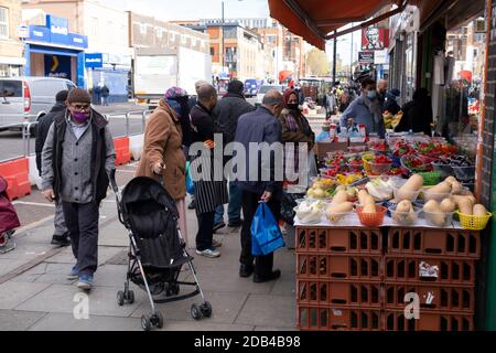 Alors que les Londoniens de la communauté principalement asiatique attendent le deuxième confinement national du coronavirus, c'est comme d'habitude au marché de Bethnal Green Road avec des gens qui sortent et s'en sortent, certains portant des masques et d'autres pas, Sur ce qui sera les quelques jours de la normalité avant un verrouillage total d'un mois au Royaume-Uni le 2 novembre 2020 à Londres, Royaume-Uni. Le système à trois niveaux au Royaume-Uni n'a pas fonctionné suffisamment pour supprimer le virus, et des politiciens ont reçu des appels pour qu'un verrouillage complet de « disjoncteur » soit annoncé pour aider à la propagation croissante du Covid-19. Banque D'Images