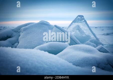 Floes de glace bleu transparent entassées dans des hummocks de glace contre un ciel bleu par temps ensoleillé. Paysage hivernal inhabituel du lac gelé Baikal. Froid naturel b Banque D'Images