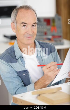 homme senior assemblant des meubles en bois Banque D'Images