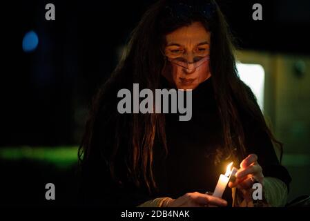 16 novembre 2020, Berlin, Berlin, Allemagne: Un manifestant avec un masque et une photo imprimée d'un visage tient une bougie devant la représentation de l'État de Hesse lors d'un rassemblement contre le défrichement de la forêt de Dannenroeder à Hesse (allemand: Hessen). Les groupes environnementaux exigent un arrêt immédiat à la construction de l'autoroute A49 prévue après qu'un activiste est tombé d'un trépied de trois à quatre mètres de haut le matin du 15 novembre, 2020 une corde de sécurité a été coupée pendant l'opération policière en cours d'évacuation dans la forêt de Dannenroeder. (Image crédit : © Jan Scheunert/ZUMA Wire) Banque D'Images