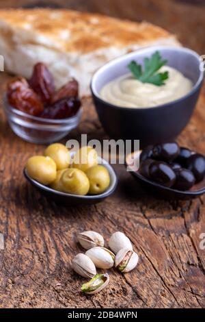 olives et houmous sur bois sombre Banque D'Images