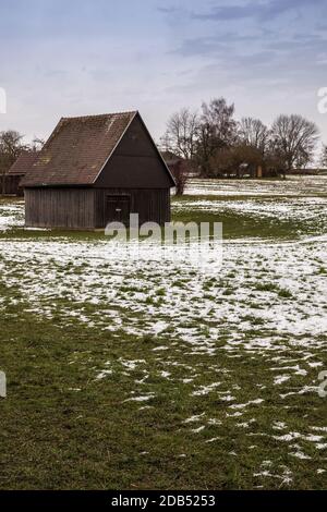 Cabine marron sur le champ vert glacé en hiver Banque D'Images