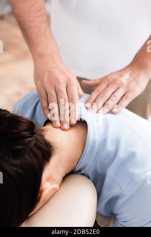 Vue rapprochée du masseur faisant un massage du cou assis pour client féminin Banque D'Images