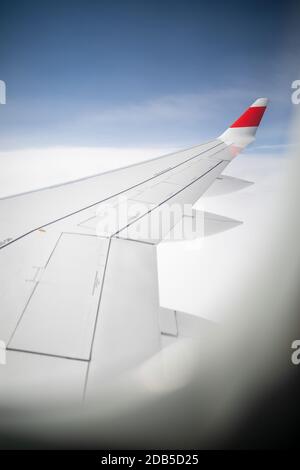 Hublot d'avion avec ciel bleu. En regardant à travers les avions de fenêtre pendant le vol. Aile d'avion à travers le hublot. En regardant à travers les avions de fenêtres du Banque D'Images