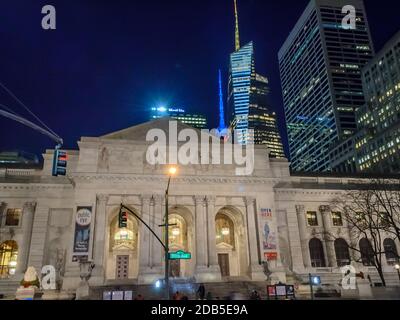 Façade de la bibliothèque publique de New York la nuit. Gratte-ciels futuristes de Manhattan en arrière-plan Banque D'Images