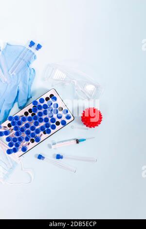 Plusieurs objets de laboratoire, dont un masque de protection, un portoir pour flacons, des tubes de test et d'autres produits. Banque D'Images