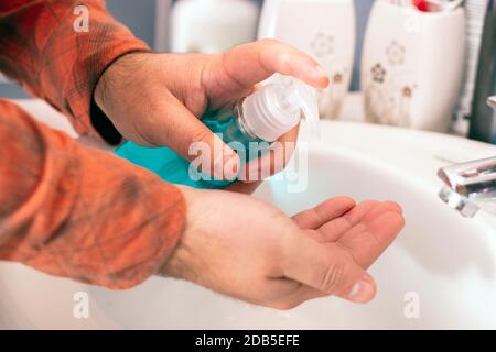 Vue rapprochée des mains application gel pour se laver les mains dans la salle de bains. Banque D'Images