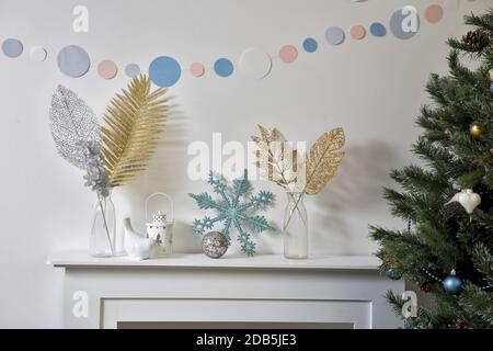 Décoration de Noël : flocon de neige bleu à paillettes artificielles, porte-bougie et porte-bougie en porcelaine blanc, figurine, bullfinch oiseau sur la console. Copier l'espace. Tropica Banque D'Images