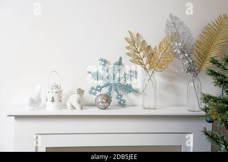 Décoration de Noël : flocon de neige bleu à paillettes artificielles, porte-bougie et porte-bougie en porcelaine blanc, figurine, bullfinch oiseau sur la console. Copier l'espace. Tropica Banque D'Images