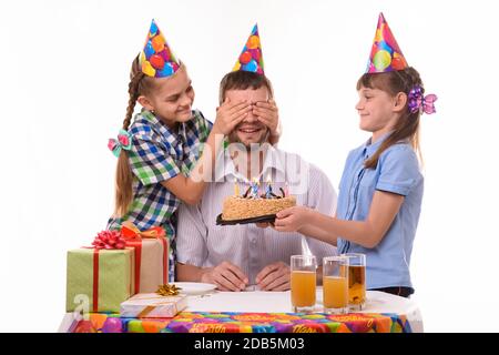 Les enfants donnent une douce surprise à leur père lors d'une fête d'anniversaire Banque D'Images