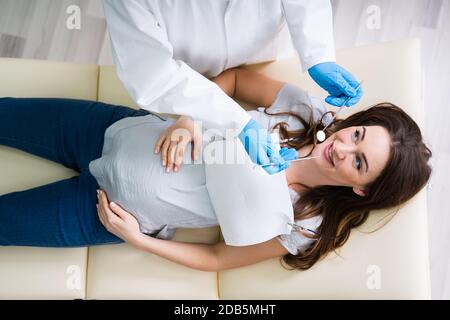 A Male Dentist Traiter Dents de jeune femme enceinte Patient Lying in Clinic Banque D'Images