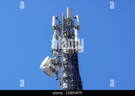 Gros plan sur la tour de répétiteur d'antenne de couleur blanche sur le ciel bleu . Banque D'Images