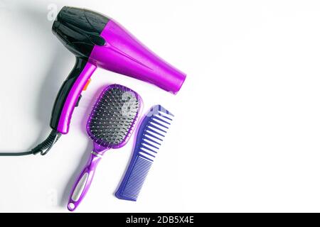 Coiffeur professionnel sur fond blanc, vue de dessus. Sèche-cheveux, brosses à cheveux, peignes. Banque D'Images