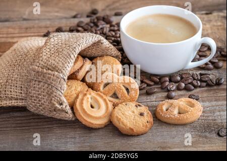 Biscuits au beurre dans un sac de burlap avec une tasse de café Banque D'Images