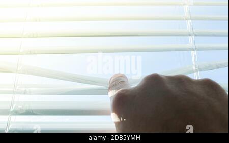 Le soleil brille à travers les stores à demi-ouverture sur la fenêtre. Banque D'Images